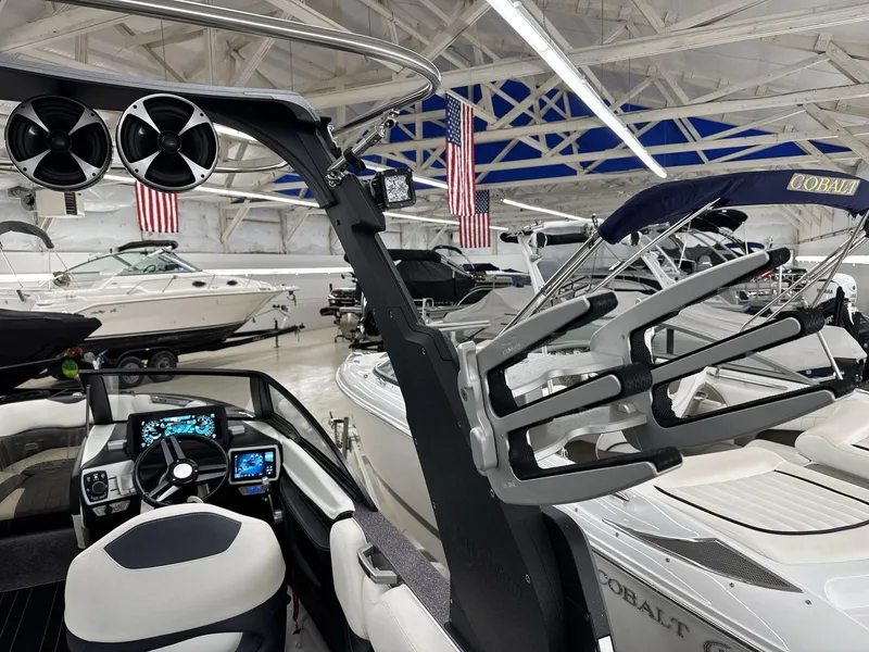 Slide: The Image of 2016 Malibu 25 LSV boat interior with advanced dashboard and sleek design in showroom. - 16