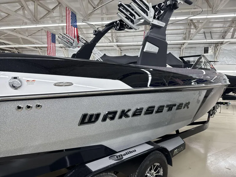 Slide: The Image of 2016 Malibu 25 LSV Wakesetter boat in showroom with American flags. - 7