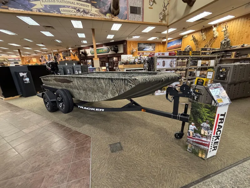 Slide: The Image of 2025 Tracker Grizzly 1650 T Prairie Wings Edition boat displayed in a showroom. - 2