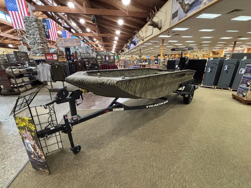 Slide: The Image of 2025 Tracker Grizzly 1650 T Prairie Wings Edition boat displayed in a store. - 3