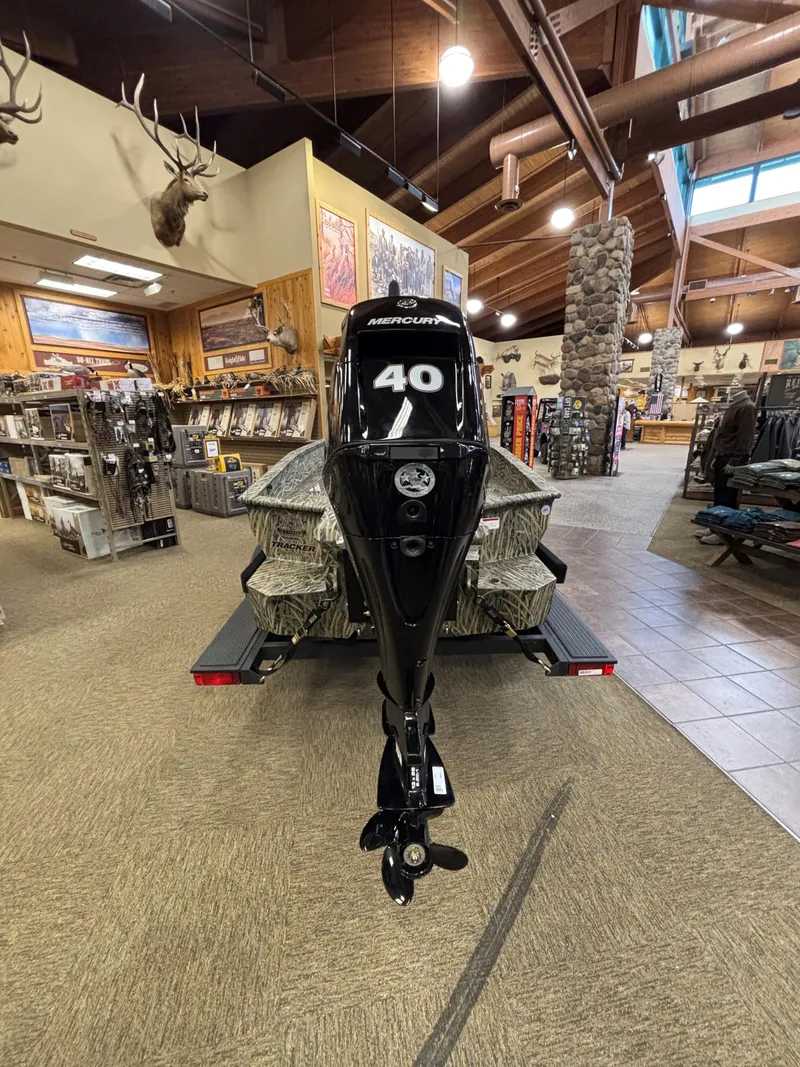 Slide: The Image of 2025 Tracker Grizzly 1650 T Prairie Wings Edition boat displayed indoors with Mercury 40 outboard motor. - 6