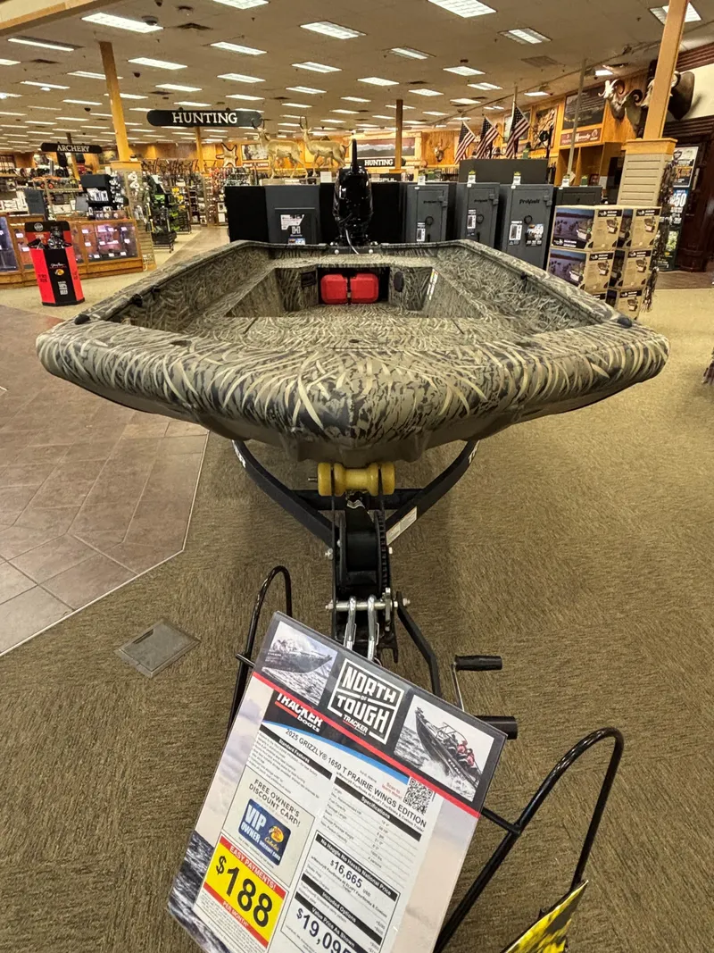 Slide: The Image of 2025 Tracker Grizzly 1650 T Prairie Wings Edition boat displayed in a store. - 9