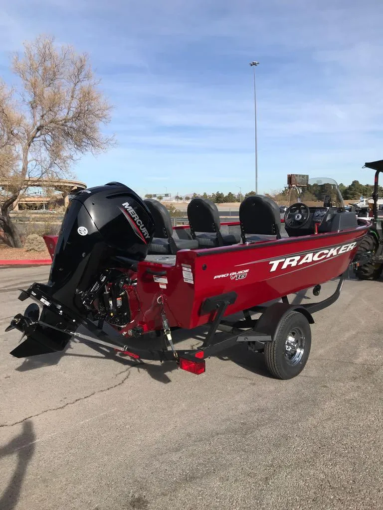 Slide: The Image of 2025 Tracker Pro Guide V-16 SC boat, red, parked outdoors. - 2
