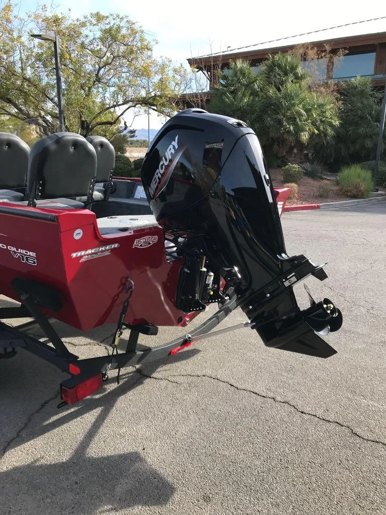 Slide: The Image of 2025 Tracker Pro Guide V-16 SC boat with Mercury outboard motor in parking lot. - 6