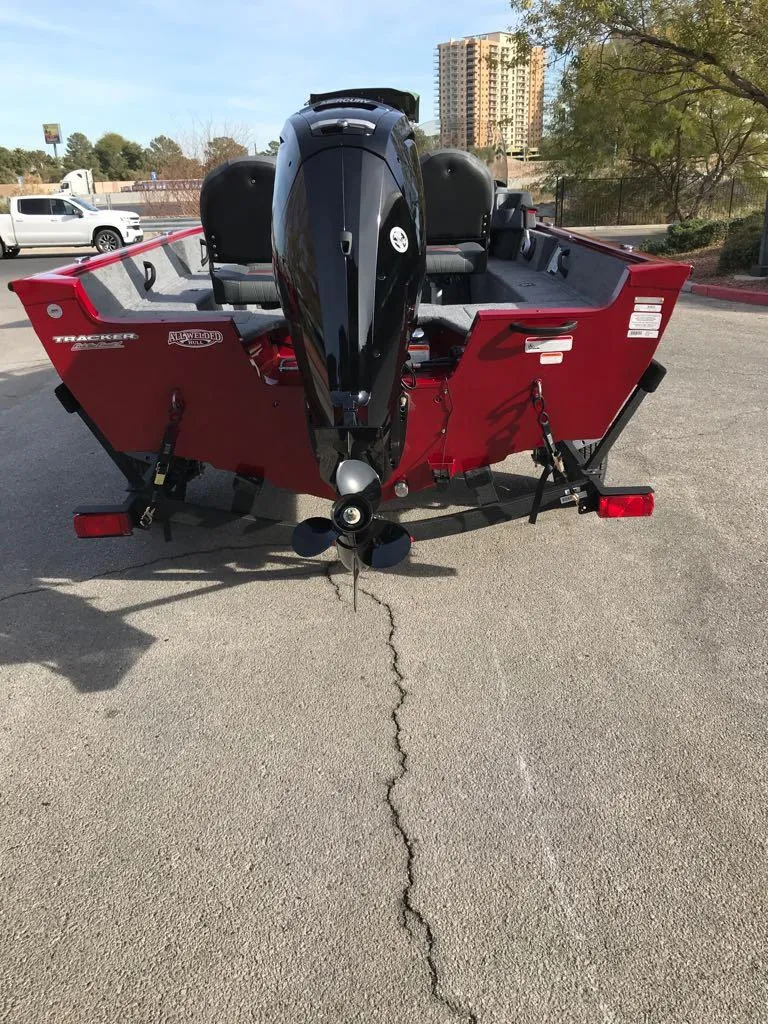 Slide: The Image of 2025 Tracker Pro Guide V-16 SC boat, rear view, parked outdoors. - 9