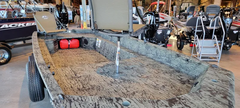 Slide: The Image of 2025 Tracker Grizzly 1650 T Prairie Wings Edition boat with camouflage interior in showroom. - 9