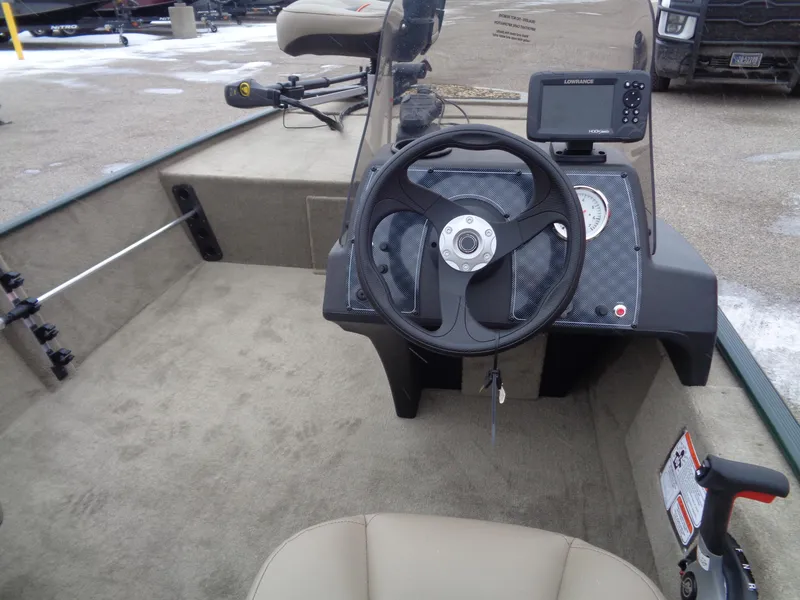Slide: The Image of 2025 Tracker Bass Tracker Classic Limited boat interior with steering wheel and navigation system. - 6
