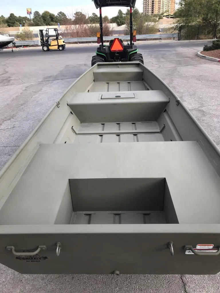 Slide: The Image of 2025 Tracker Grizzly 1542 Utility boat, parked outdoors, showcasing spacious interior design. - 4