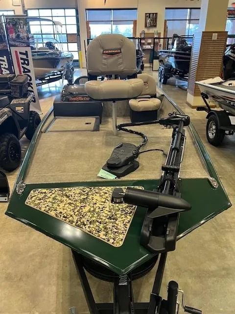 Slide: The Image of 2025 Tracker Bass Tracker Classic Limited boat displayed in showroom, featuring trolling motor and seating. - 2