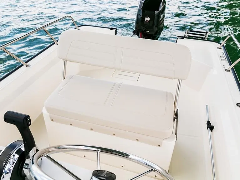 Slide: The Image of 2025 Boston Whaler 150 Montauk boat interior with steering wheel and seating. - 20