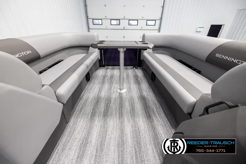 Slide: The Image of 2025 Bennington 23 SSBSE boat interior with gray seating and table in a showroom. - 19