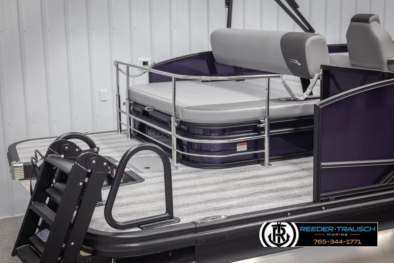 Slide: The Image of 2025 Bennington 23 SSBSE pontoon boat with seating, ladder, and railing in showroom. - 49