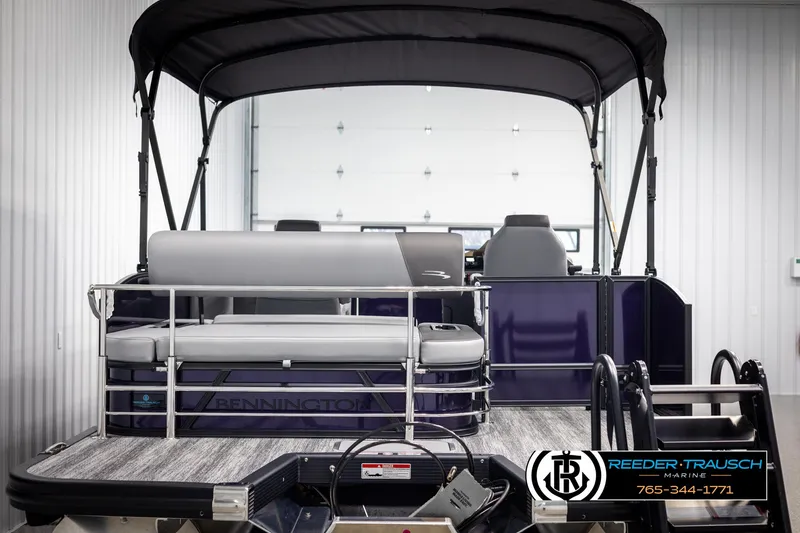 Slide: The Image of 2025 Bennington 23 SSBSE pontoon boat with canopy and seating, displayed indoors. - 7