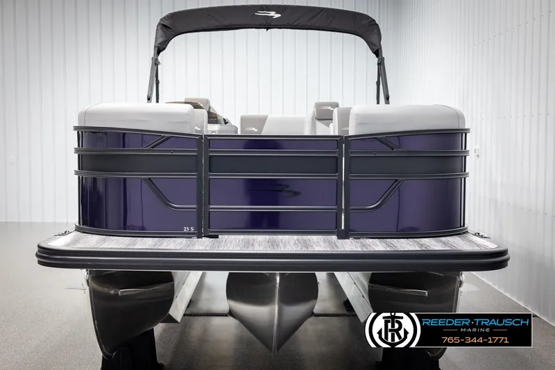 Slide: The Image of 2025 Bennington 23 SSBSE pontoon boat in showroom, front view, with Reeder-Trausch Marine logo. - 8