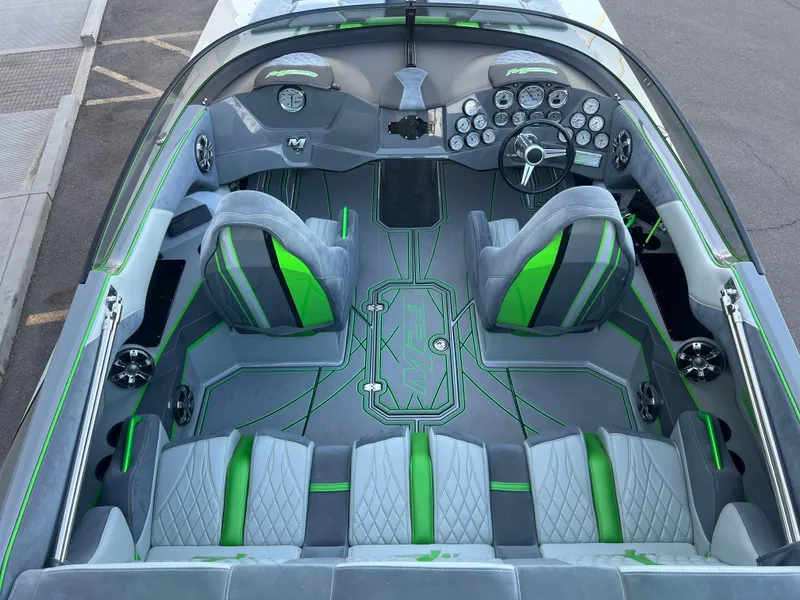 Slide: The Image of 2015 Daves Custom Boats M-29 interior with green and gray seating, modern dashboard. - 6