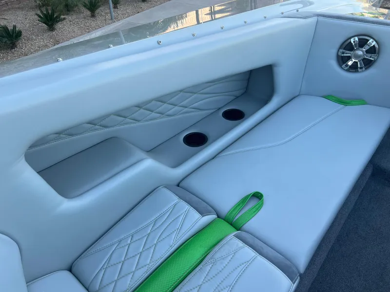 Slide: The Image of 2015 Daves Custom Boats M-29 interior with gray and green seating, cup holders, and speaker. - 9