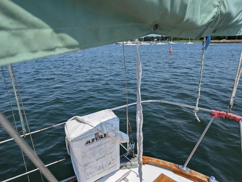 Slide: The Image of Hinckley Bermuda 40 Yawl, 1974, sailing on calm waters with visible lifebuoy. - 17