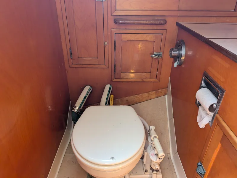 Slide: The Image of 1974 Hinckley Bermuda 40 Yawl bathroom with wooden cabinetry and marine toilet. - 30