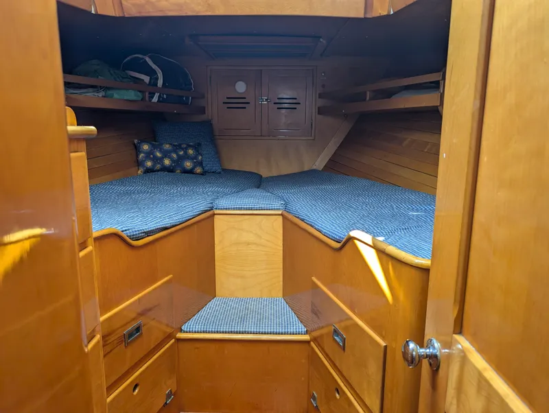 Slide: The Image of 1974 Hinckley Bermuda 40 Yawl cabin interior with wooden finish and cozy bedding. - 33