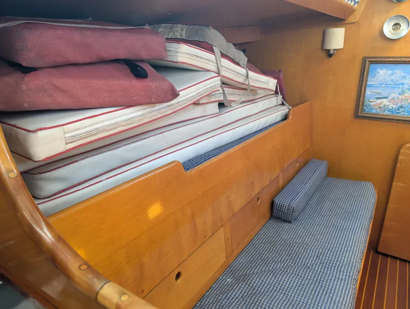 Slide: The Image of Interior of 1974 Hinckley Bermuda 40 Yawl with stacked cushions and wooden paneling. - 44