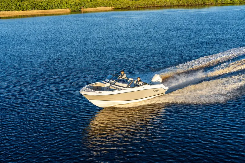 Slide: The Image of 2024 Boston Whaler 210 Vantage cruising on a serene lake. - 19