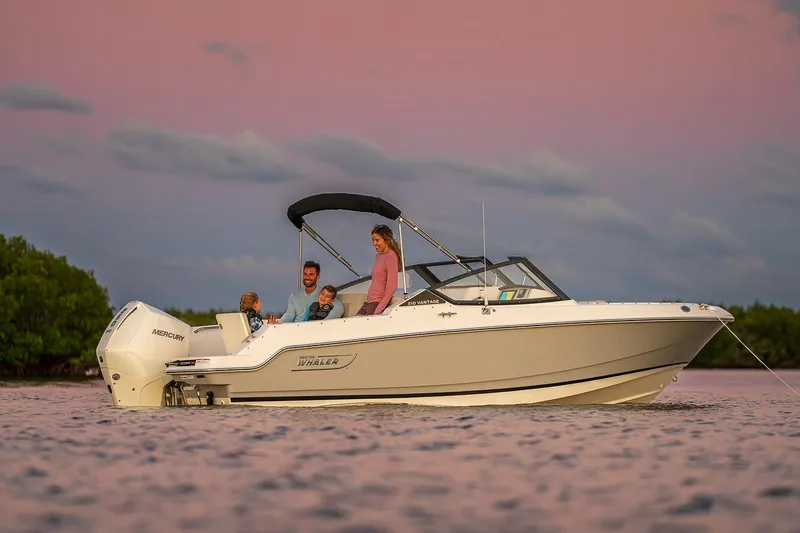 Slide: The Image of 2024 Boston Whaler 210 Vantage boat on calm water at sunset with passengers. - 5