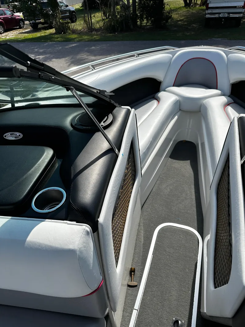 Slide: The Image of 2002 Malibu Wakesetter XTi boat interior with white and black seating, cup holders, and open bow design. - 18