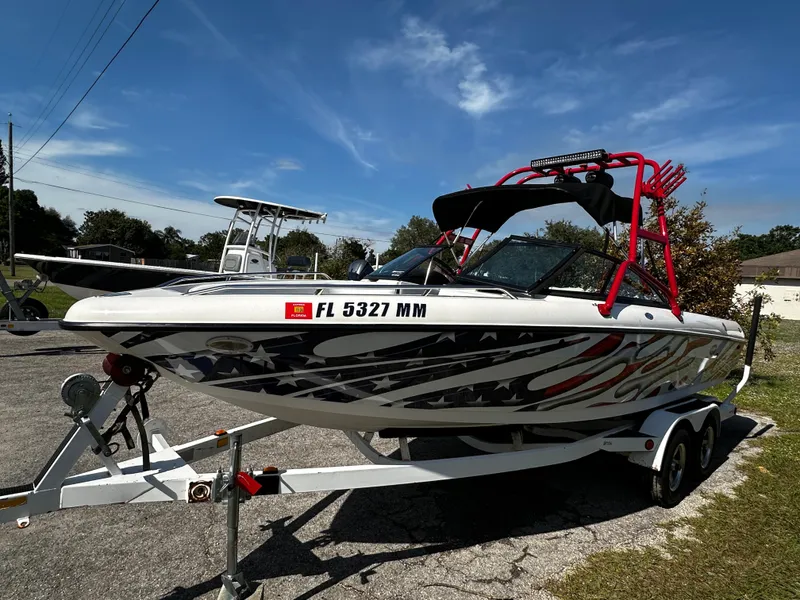 Slide: The Image of 2002 Malibu Wakesetter XTi boat on trailer, vibrant graphics, sunny day. - 2
