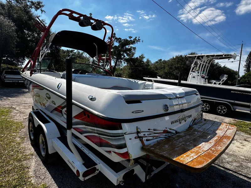 Slide: The Image of 2002 Malibu Wakesetter XTi boat on trailer, parked outdoors under a clear sky. - 3