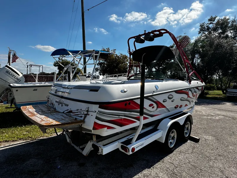 Slide: The Image of 2002 Malibu Wakesetter XTi boat on trailer, vibrant graphics, sunny day. - 4