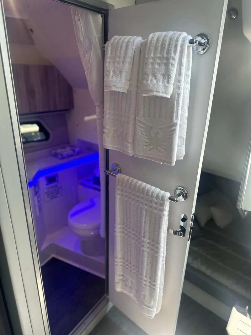 Slide: The Image of 2022 Formula 380 Super Sport Crossover OB bathroom with towels and blue LED lighting. - 11