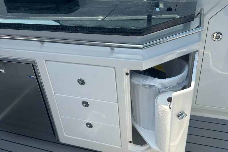Slide: The Image of 2022 Formula 380 Super Sport Crossover OB boat interior with storage and trash compartment. - 14