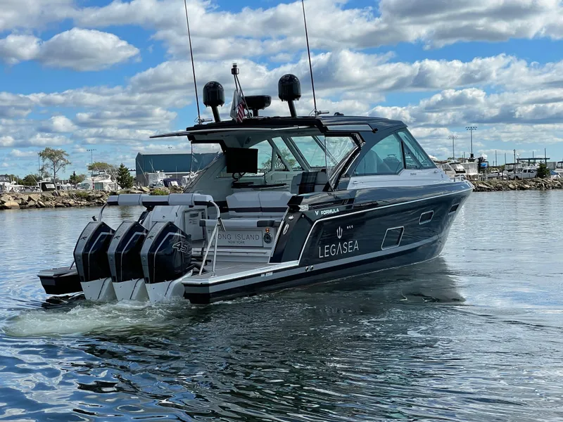 Slide: The Image of 2022 Formula 380 Super Sport Crossover OB boat on water, featuring triple outboard engines. - 2