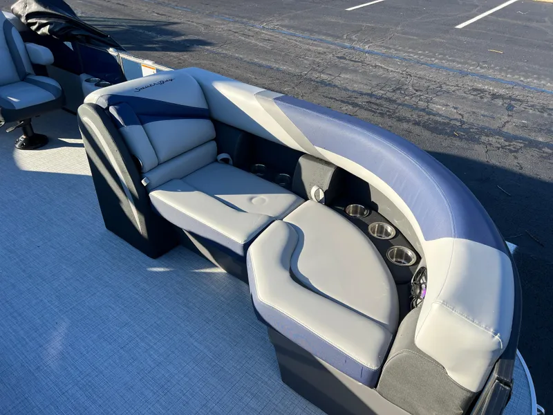 Slide: The Image of 2025 South Bay 224 RS Performance Package boat seating with cup holders, featuring blue and gray upholstery. - 9