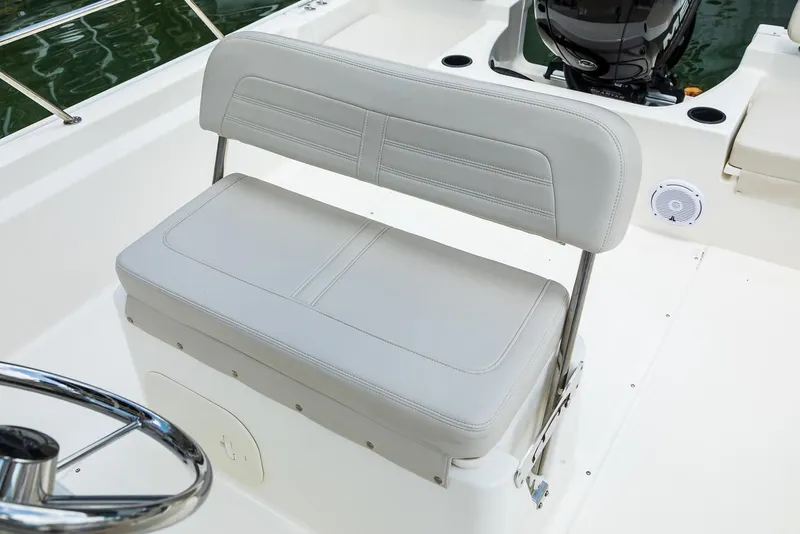 Slide: The Image of 2025 Boston Whaler 190 Montauk boat interior with cushioned seating and steering wheel. - 17