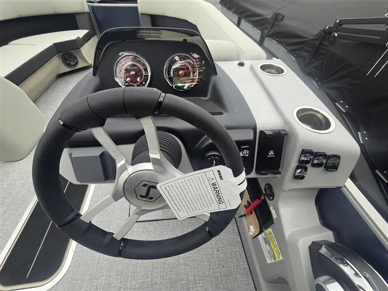Slide: The Image of 2025 Harris Cruiser 230 boat dashboard with steering wheel and control panel. - 3
