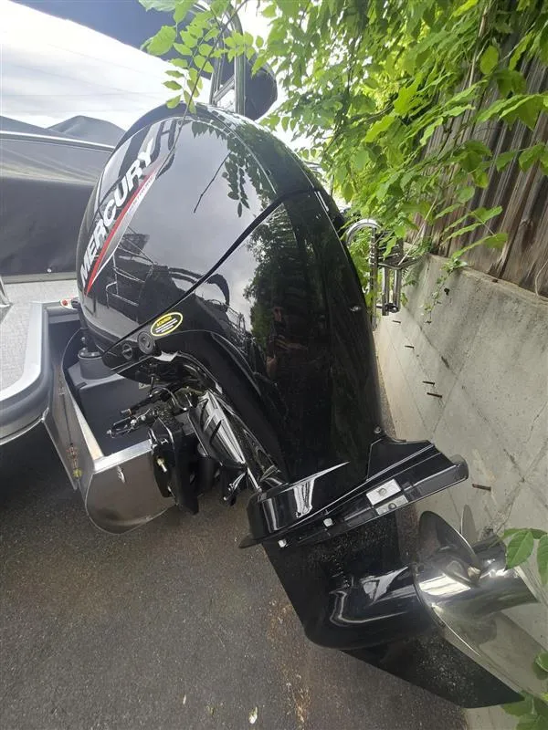 Slide: The Image of 2025 Harris Cruiser 230 with Mercury outboard motor, parked outdoors. - 9