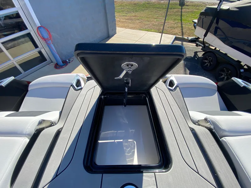Slide: The Image of 2021 MasterCraft X26 boat storage compartment open, showcasing sleek design and functionality. - 10