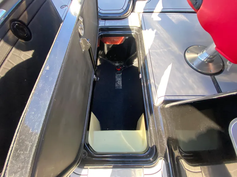 Slide: The Image of 2021 MasterCraft X26 boat storage compartment with open hatch and seating area. - 30
