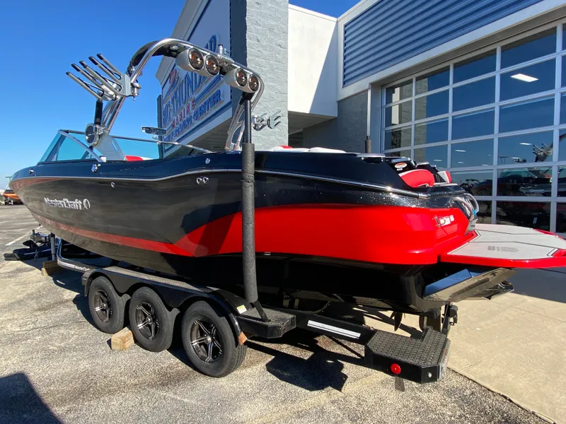 Slide: The Image of 2021 MasterCraft X26 boat with red and black design on a trailer. - 4
