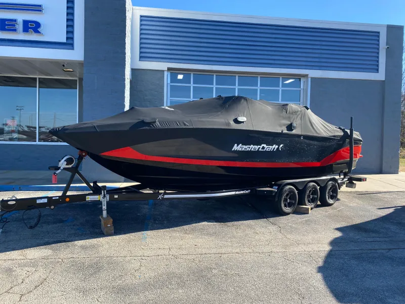 Slide: The Image of 2021 MasterCraft X26 boat with cover on trailer outside dealership. - 48