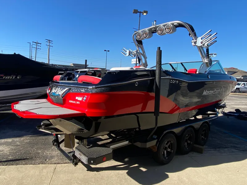 Slide: The Image of 2021 MasterCraft X26 boat with red and black design on a trailer. - 5