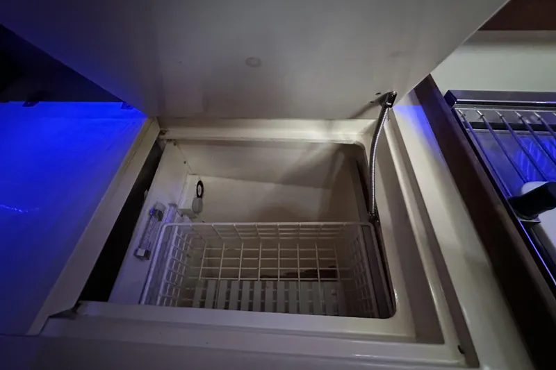 Slide: The Image of Open storage compartment on 1989 Canadian Sailcraft CS40 yacht, featuring a wire basket. - 11