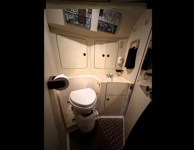 Slide: The Image of 1989 Canadian Sailcraft CS40 yacht bathroom with toilet, sink, and storage cabinets. - 19