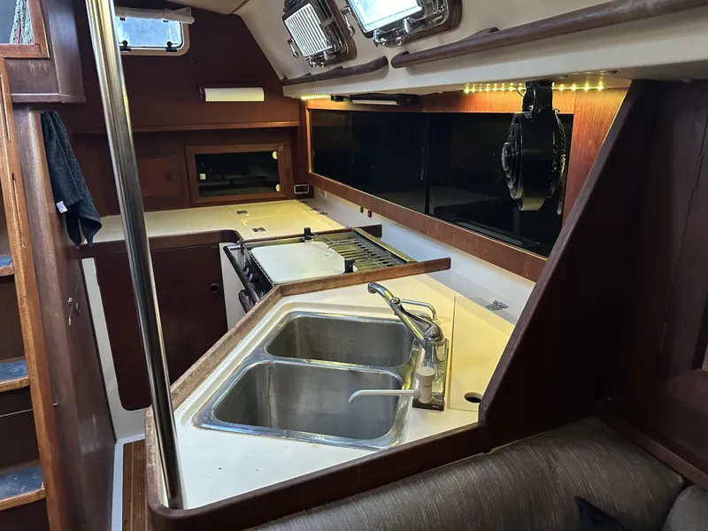 Slide: The Image of 1989 Canadian Sailcraft CS40 yacht interior with kitchen, dual sinks, and wooden cabinetry. - 7