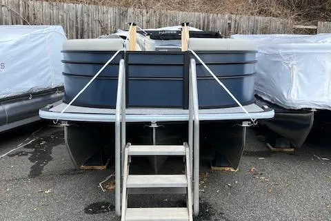 Slide: The Image of 2025 Harris Cruiser 210 pontoon boat, blue exterior, docked with ladder access. - 2
