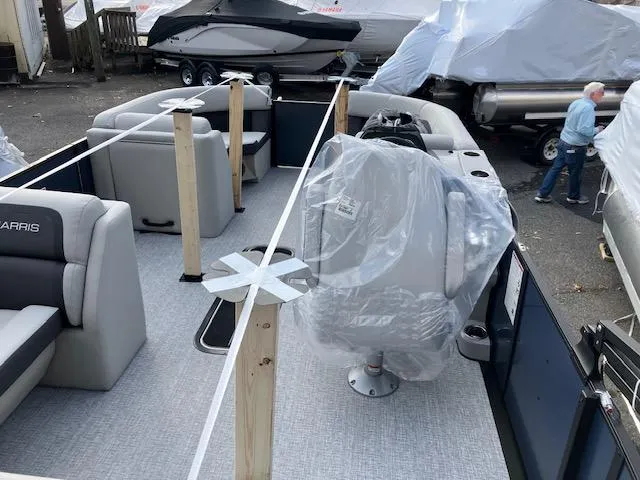 Slide: The Image of 2025 Harris Cruiser 210 pontoon boat interior with protective coverings and seating. - 3