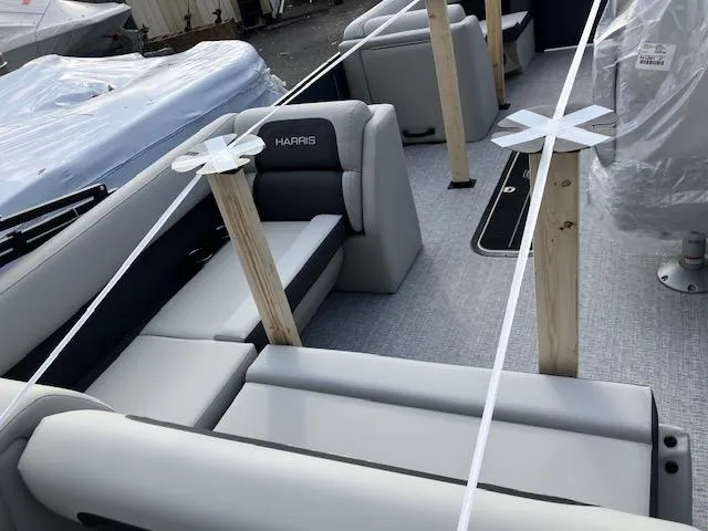 Slide: The Image of 2025 Harris Cruiser 210 boat interior with gray seating and protective coverings. - 4