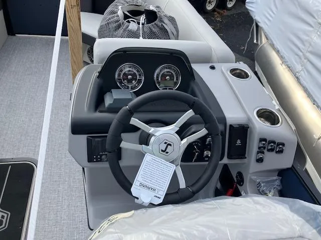 Slide: The Image of 2025 Harris Cruiser 210 boat dashboard with steering wheel and gauges. - 6