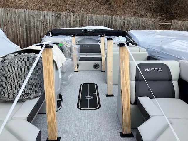 Slide: The Image of 2025 Harris Cruiser 210 pontoon boat interior with protective coverings and wooden supports. - 9